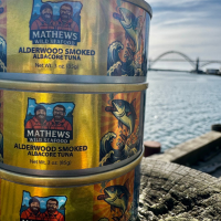 Mathews Family albacore tuna cans photographed in front of the Yaquina Bay Bridge in Newport, OR